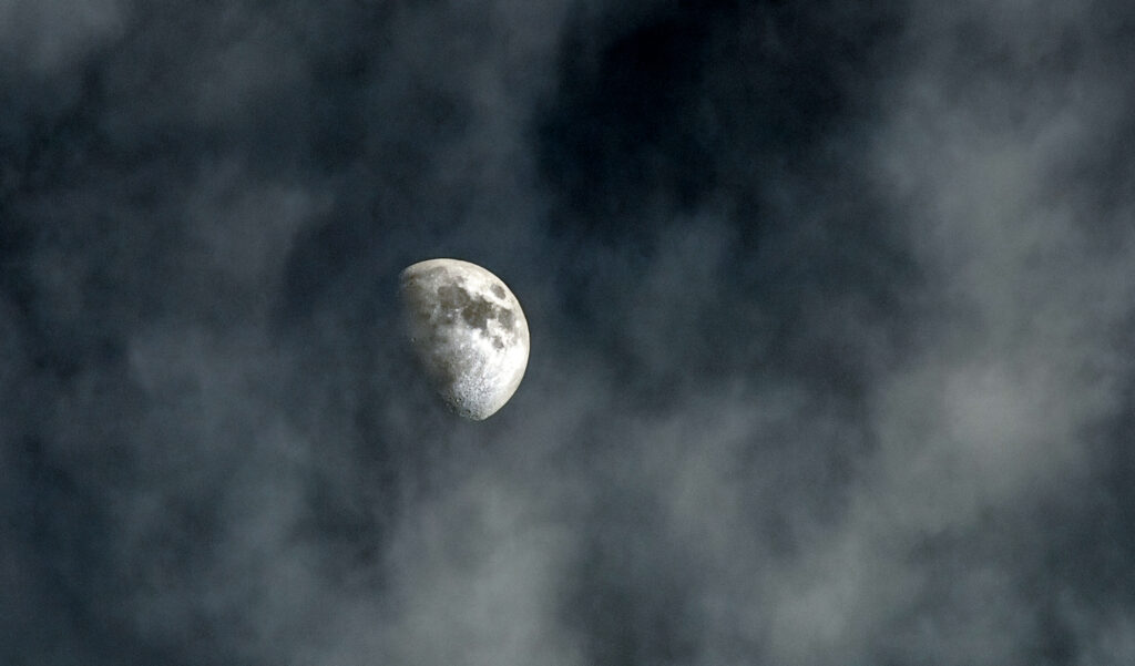 The moon glowing through wispy clouds, evoking peace and wonder in a family nighttime rhythm
