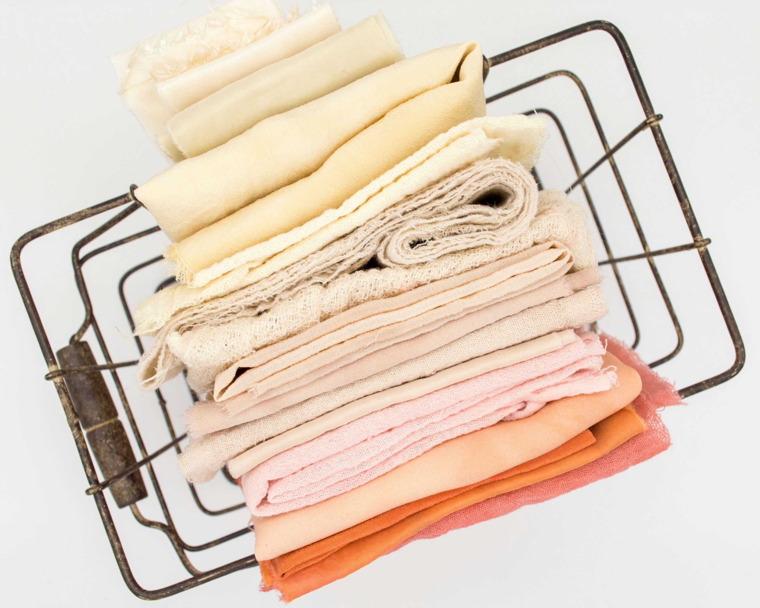Stack of folded organic baby clothes in brand color palette — sustainable children’s apparel